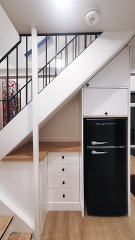 Every home can use more storage. Fortunately, the often-neglected space beneath a staircase provides an ideal spot for that. From kitchen pantry , home office to bookshelves. The options are virtually endless.

In addition to the fridge & storage the back of the cabinet act as beautiful paneled wall.