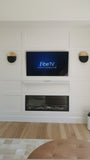 Custom built media wall with a recessed niche for the flat screen TV,  an electric fireplace  and board and batten wall treatment gives this space a cozy sleek & modern look. 